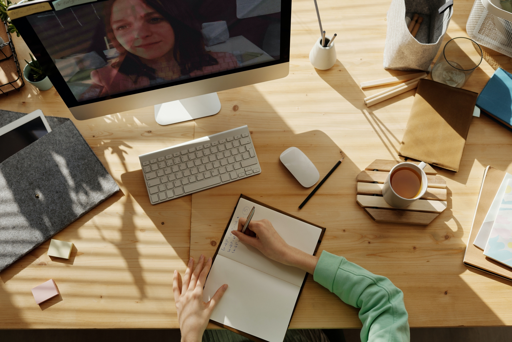 A woman taking notes in a virtual classroom