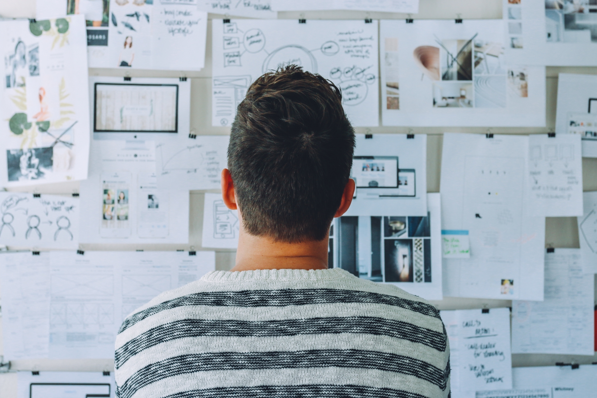 A man looking at a cluttered note board