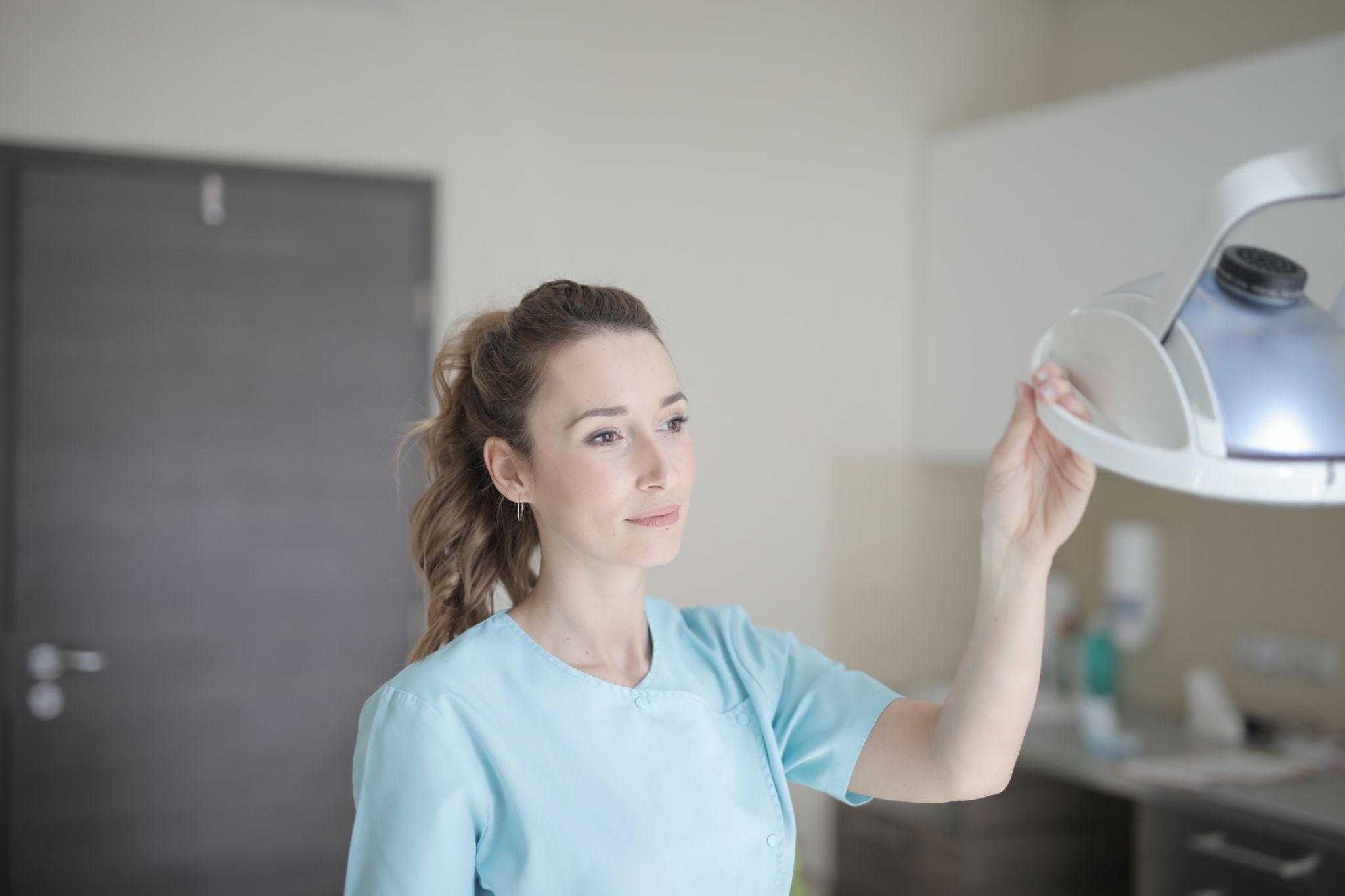 Female healthcare worker adjusting a light