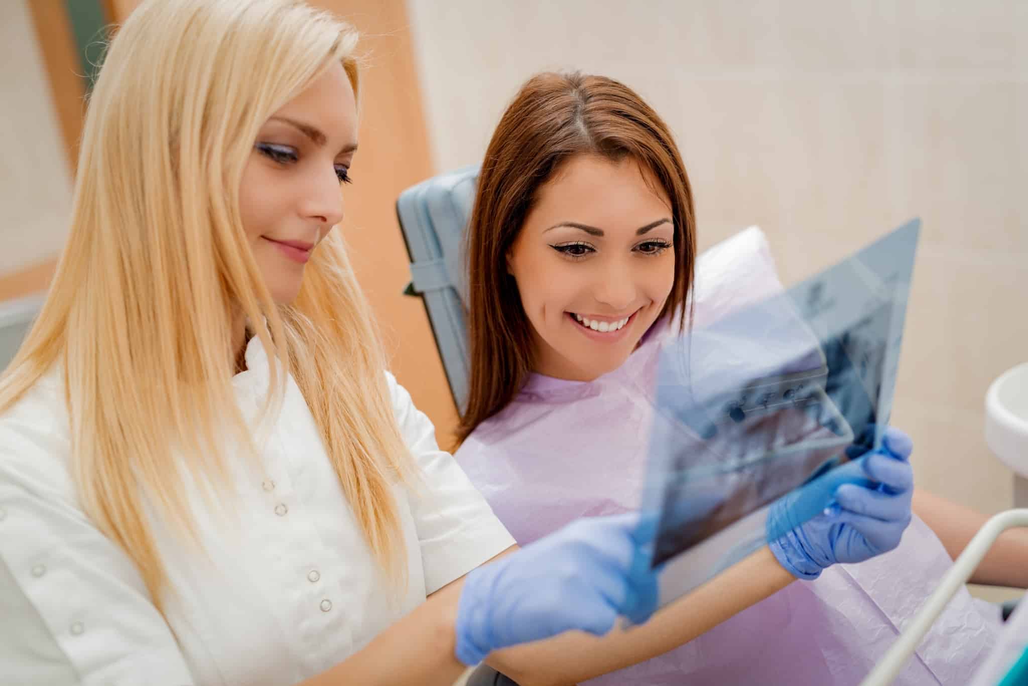 Dentist showing her patient dental X-rays