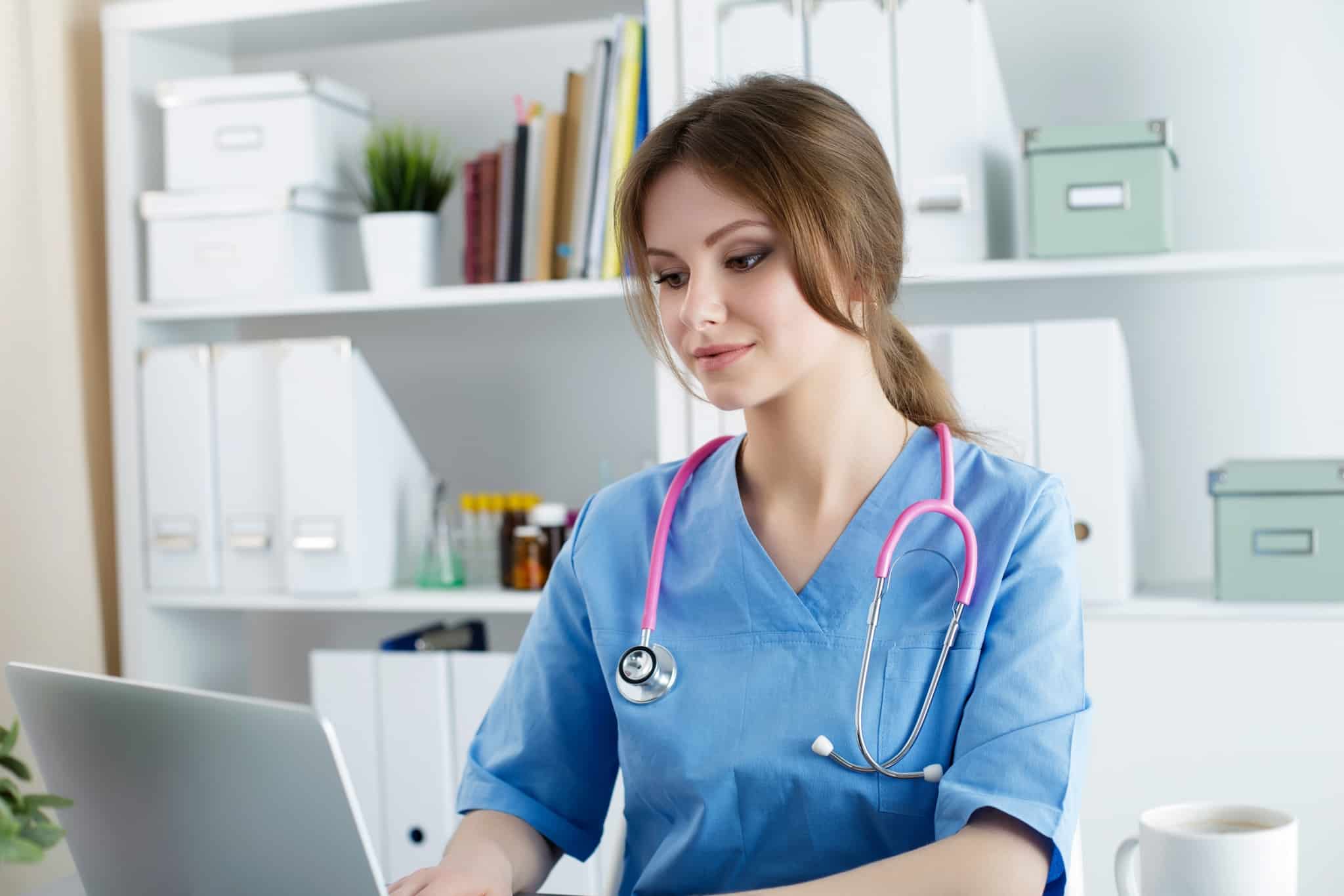 Medical professional typing on a laptop