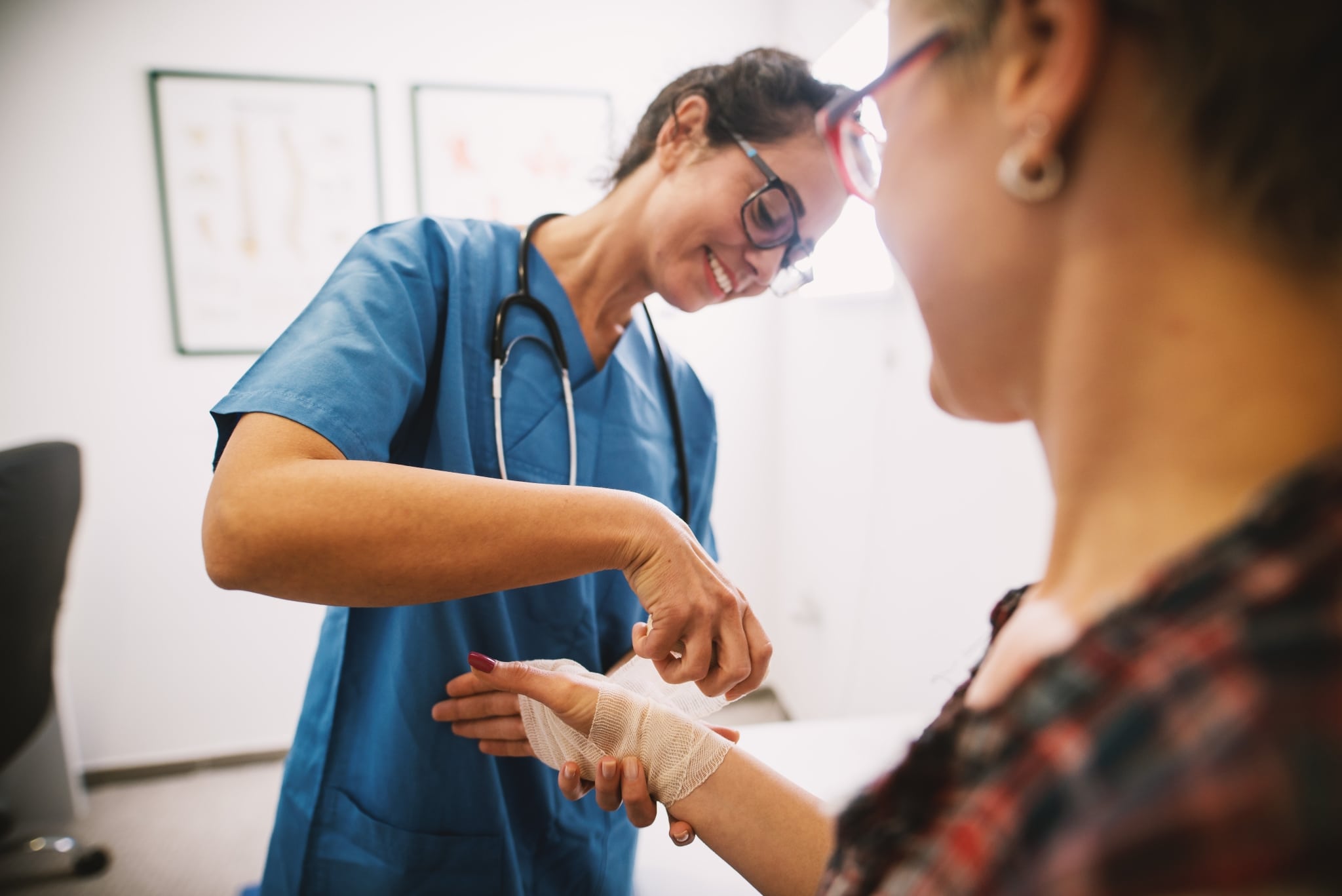 Nurse bandaging a patient's hand