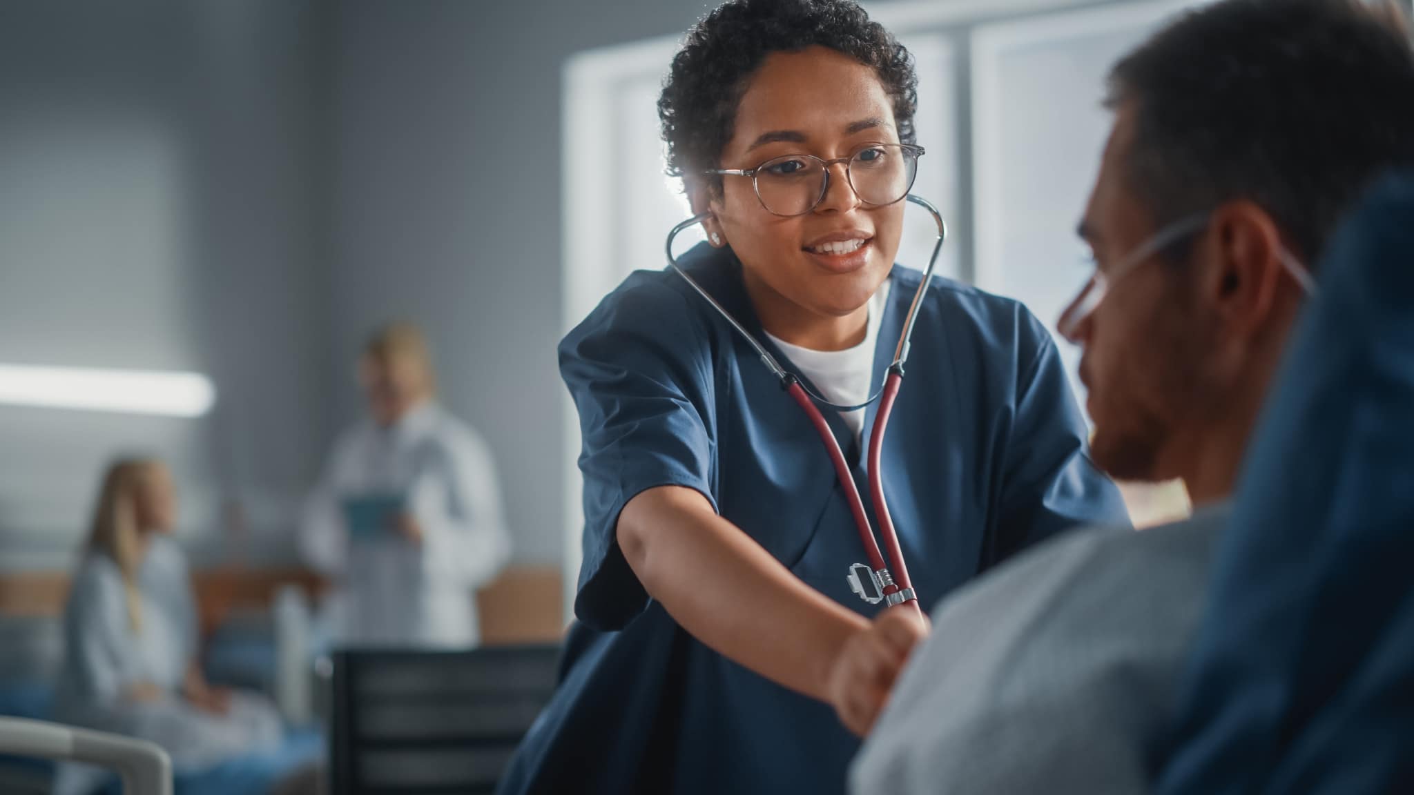 Nurse using stethoscope on male patient
