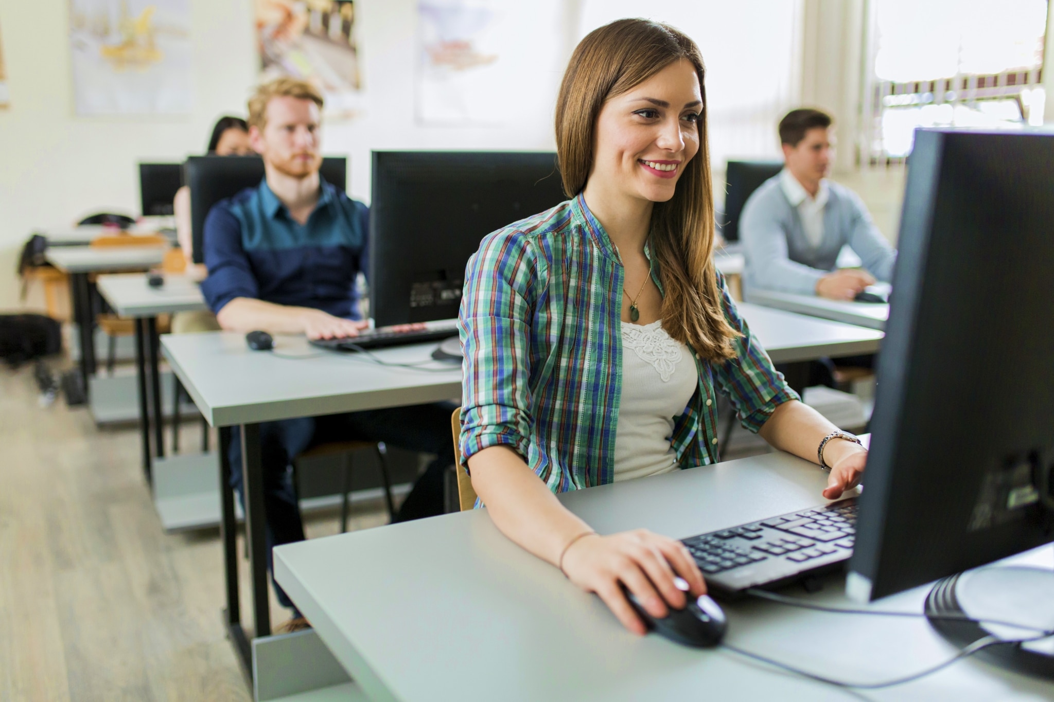 Young adults using computers in a classroom