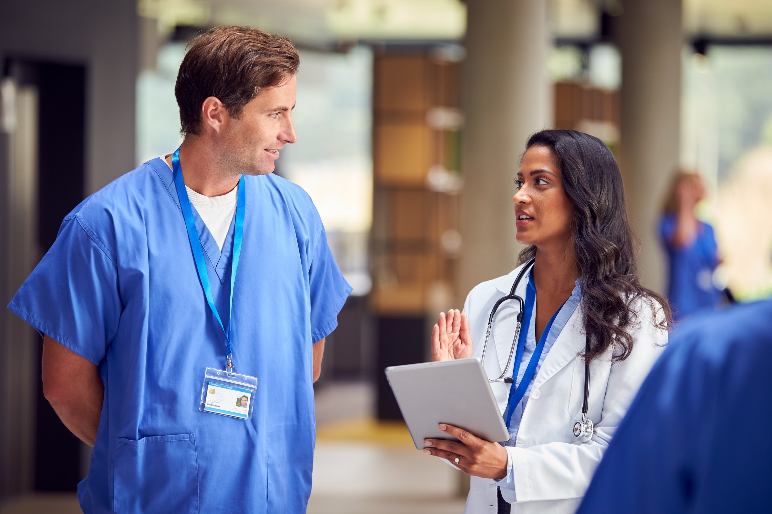 Two medical professionals in scrubs and lab coats