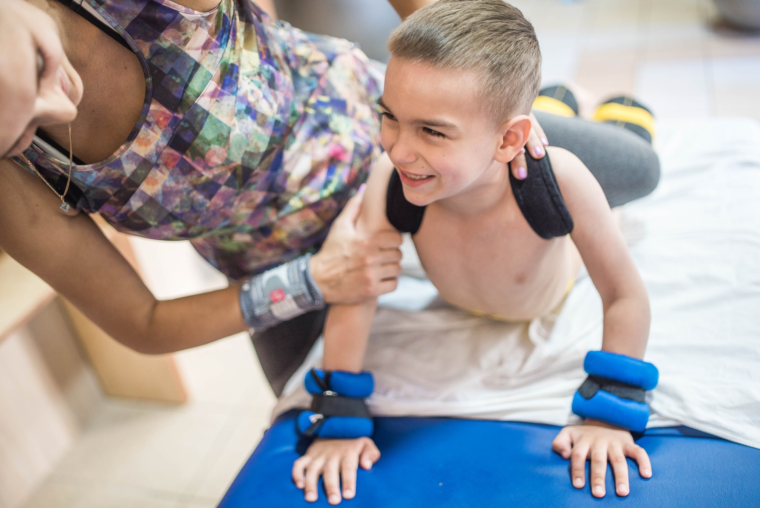 Young patient performing exercises with a Physical Therapist Assistant