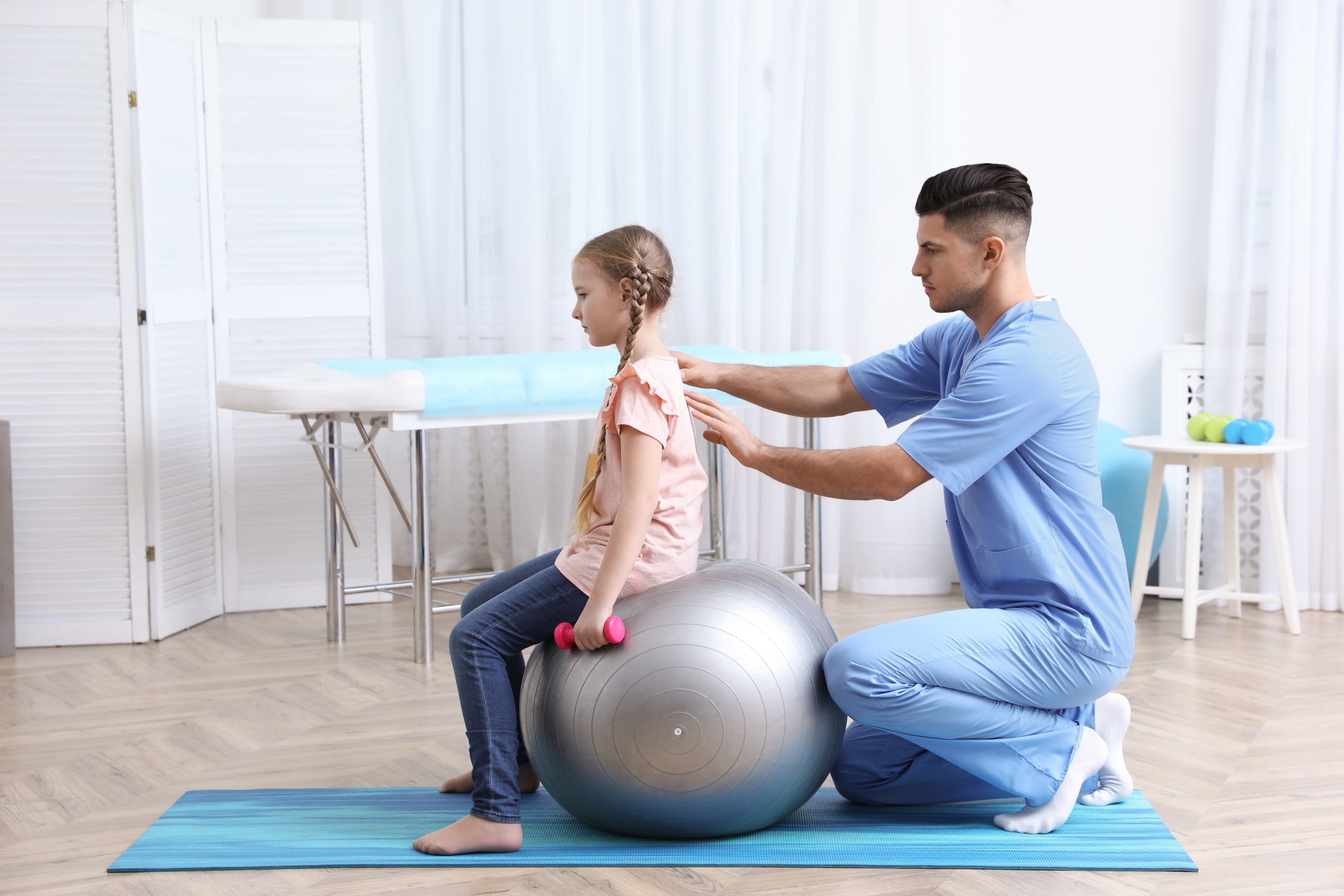 Physical Therapist Assistant helping a young female patient through exercises