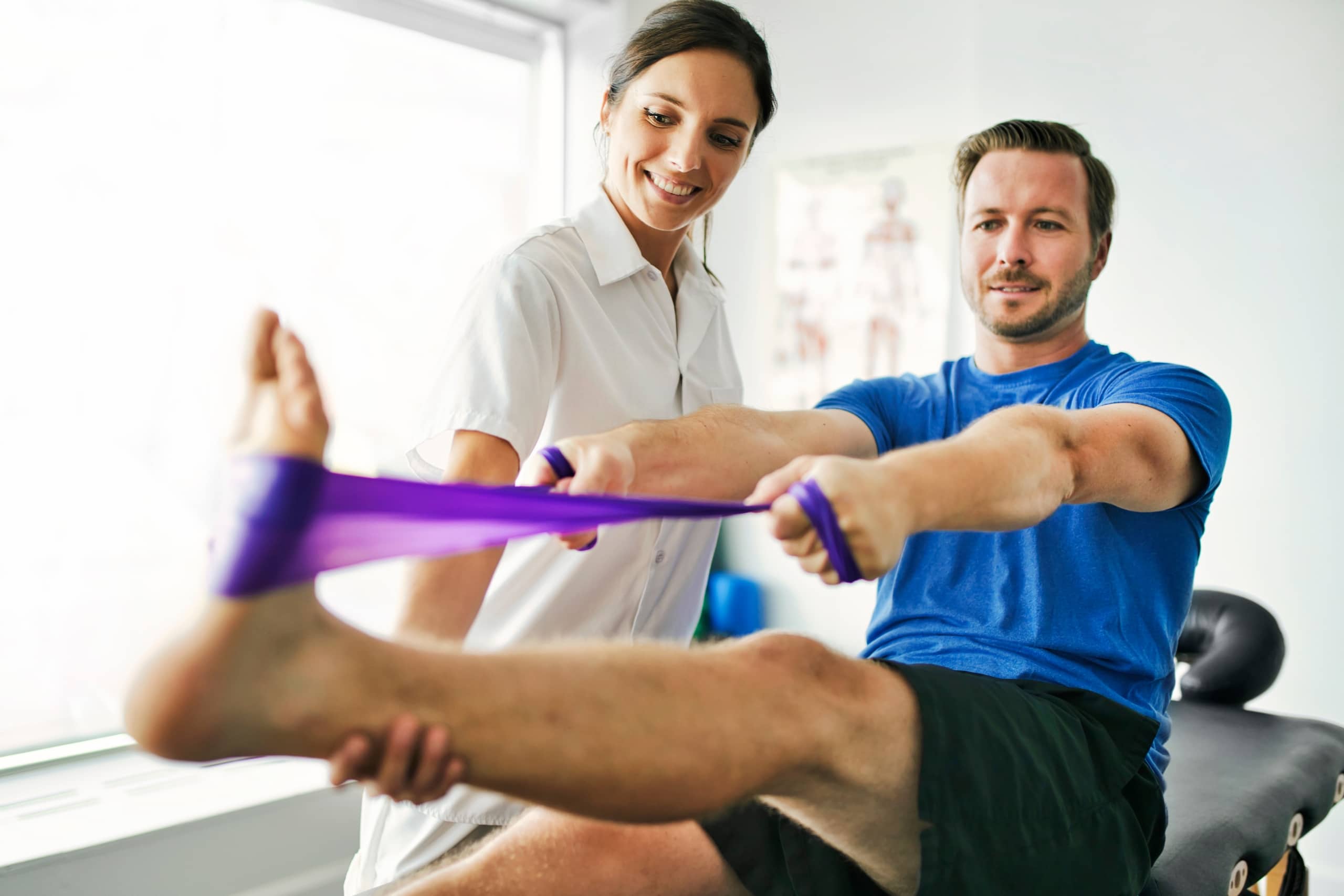 A physiotherapist helping a patient use an exercise band