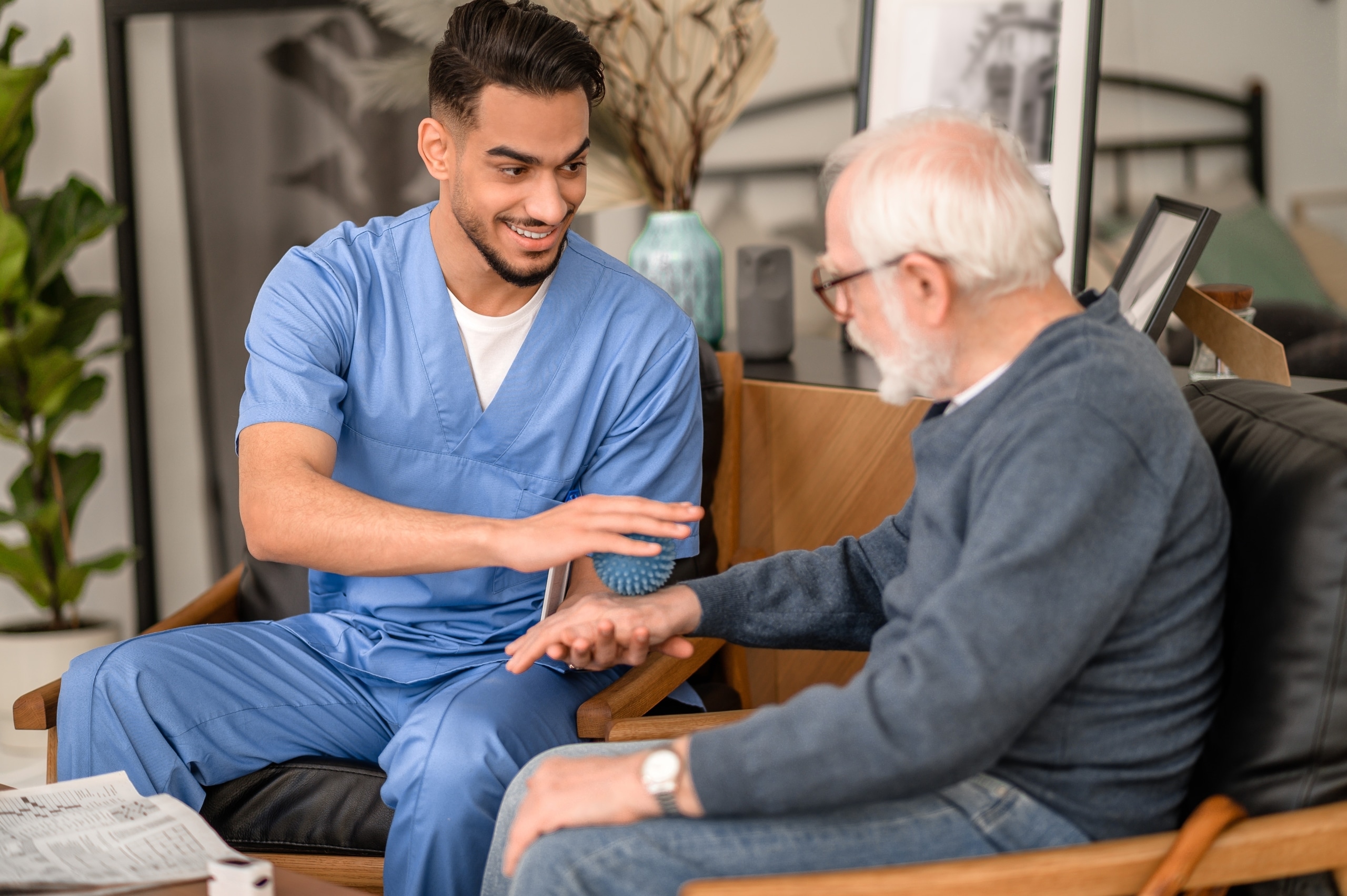Physiotherapist using a massage ball on an elderly patient