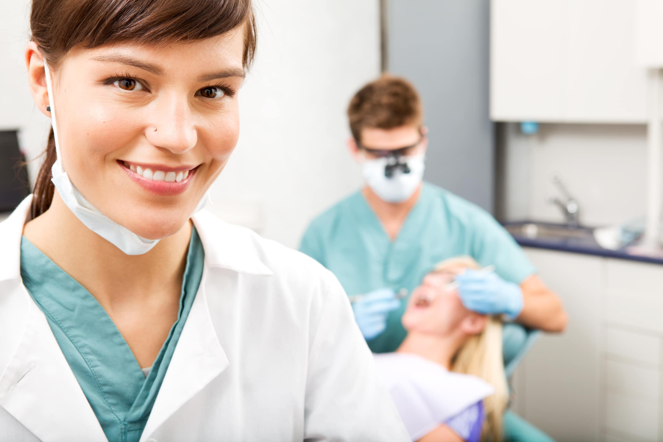 Dental professional smiling in an exam room
