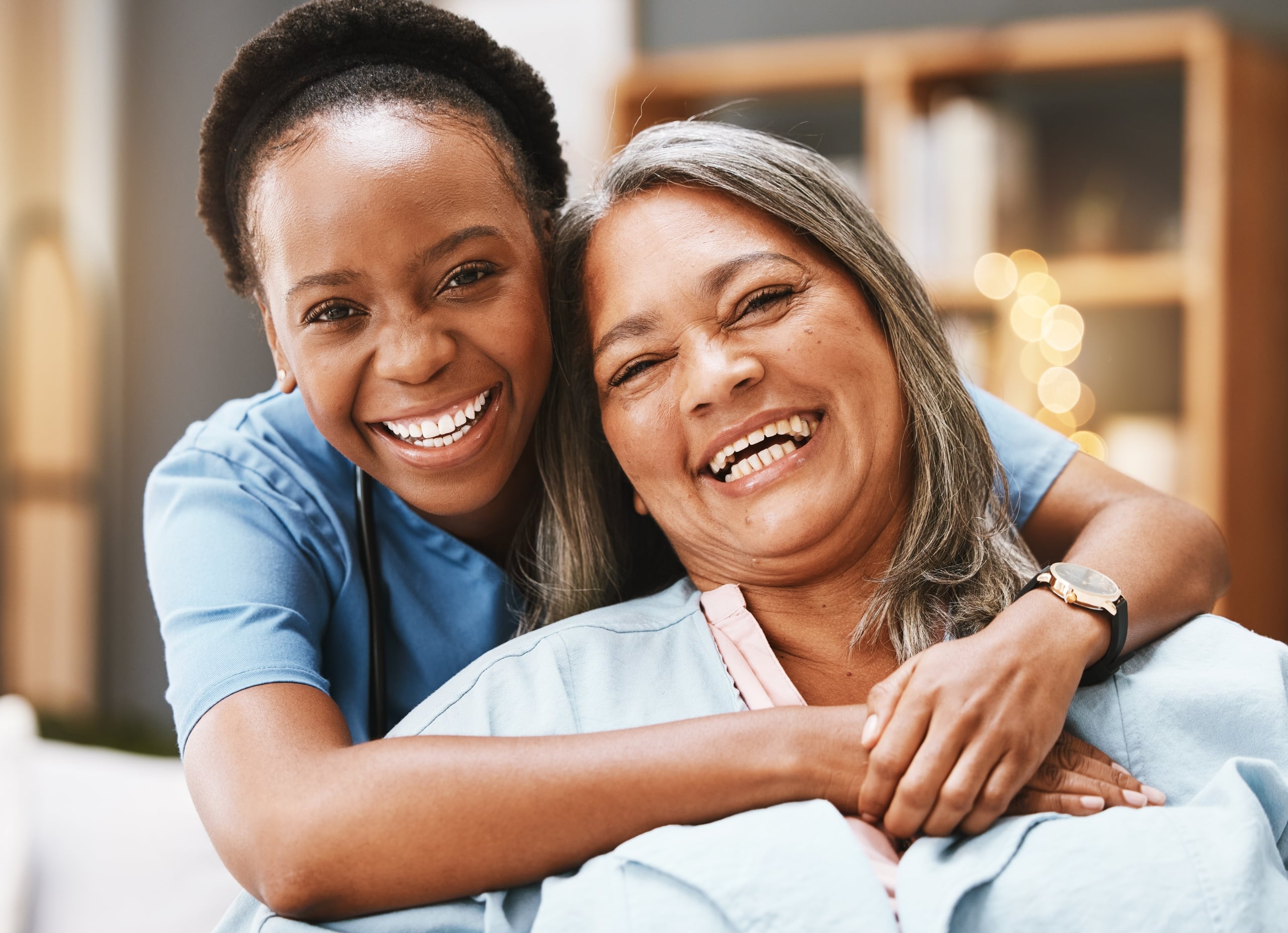African-American nurse hugging an elderly female patient