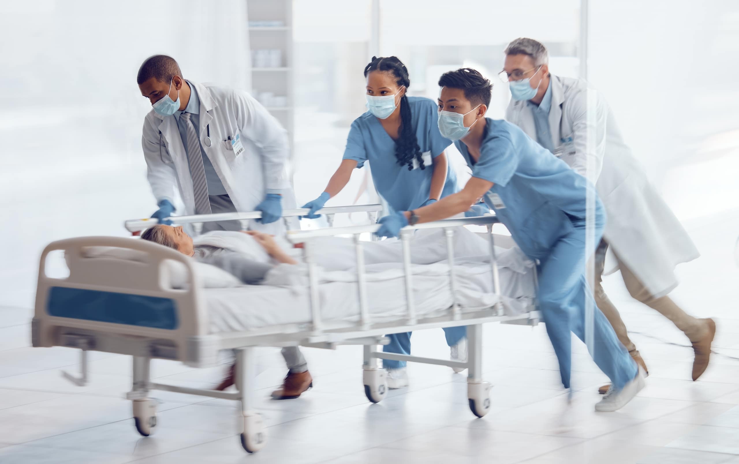 Medical professionals in the ER transporting a patient