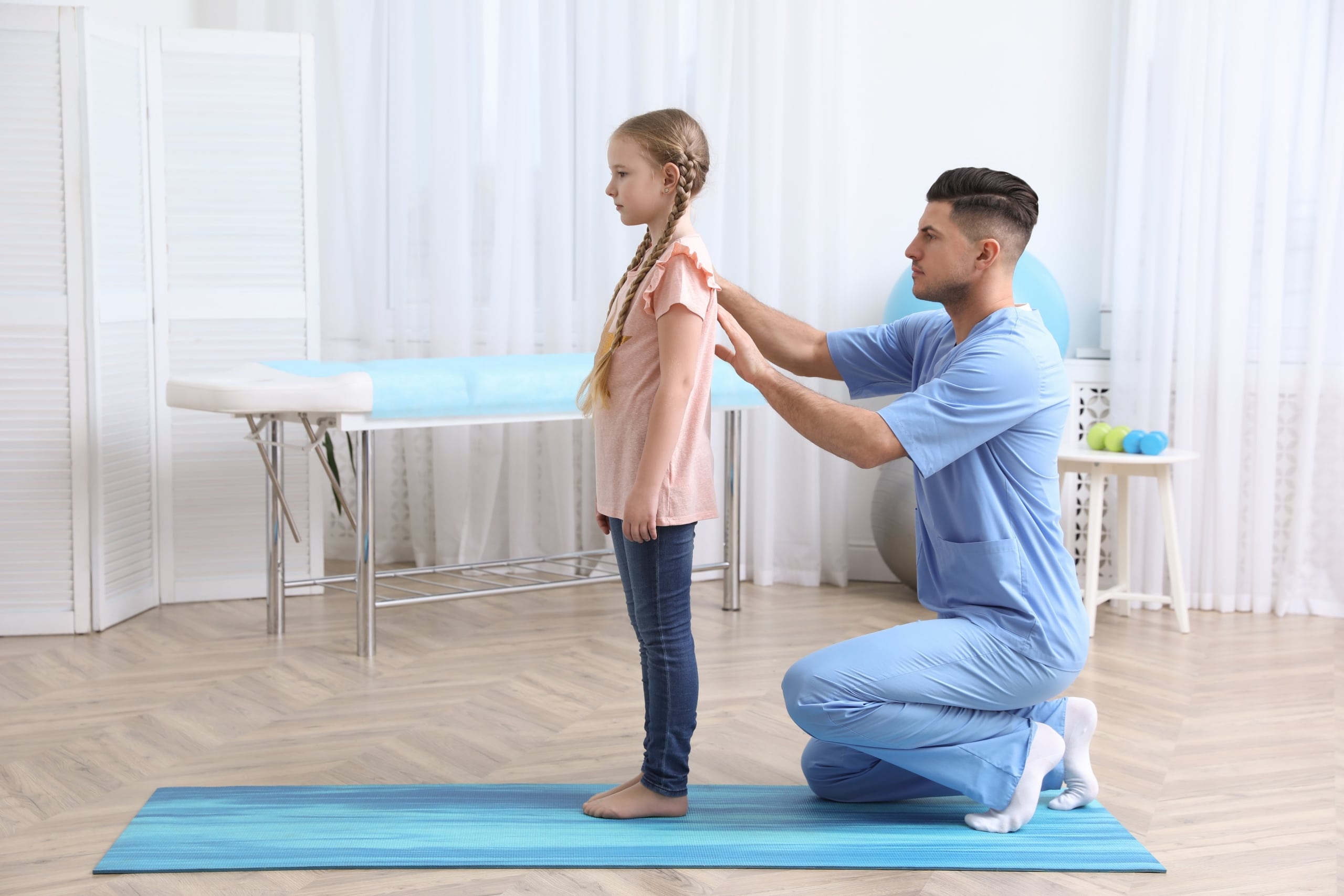 Physical therapist assistant studying a patient's back