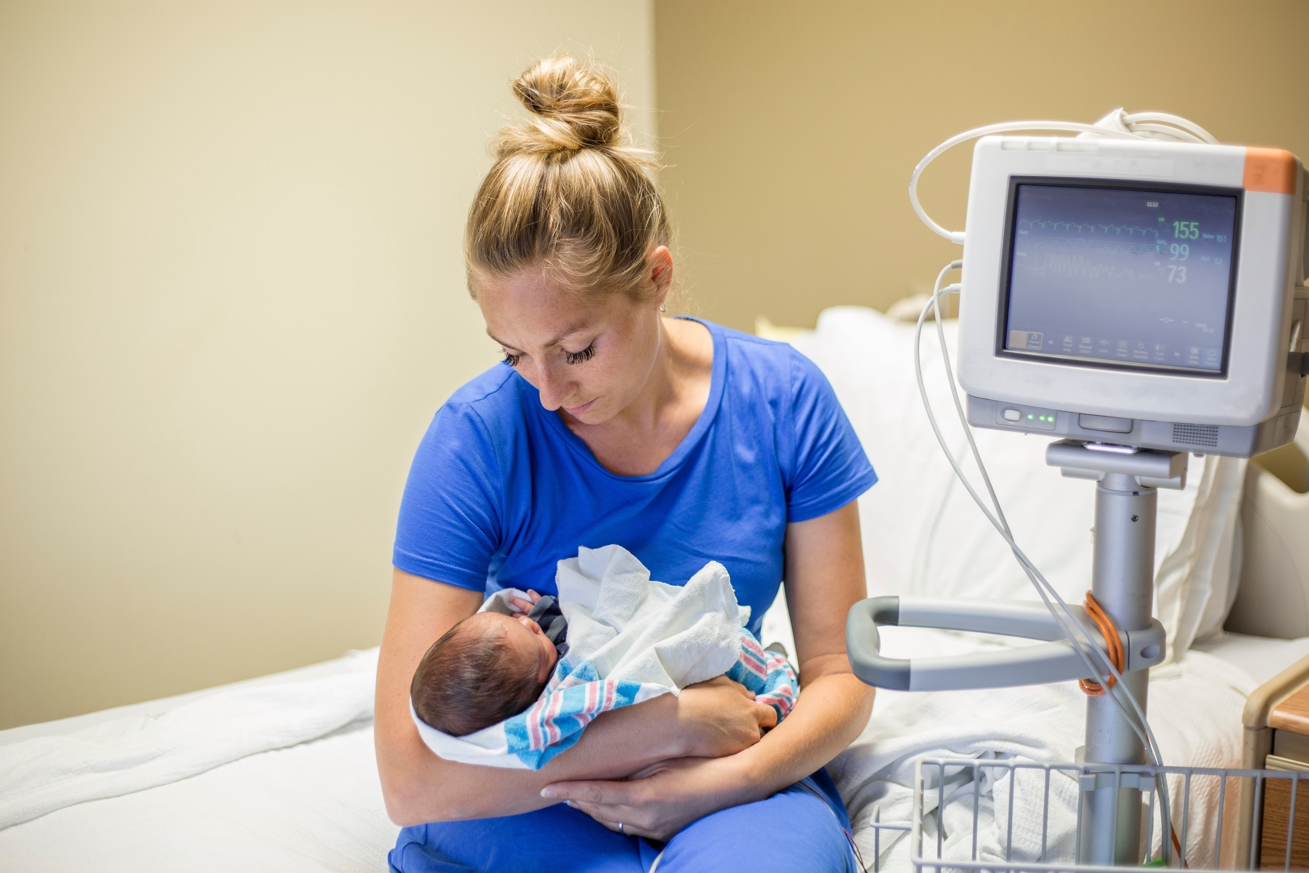 Neonatal nurse holding a baby in the NICU