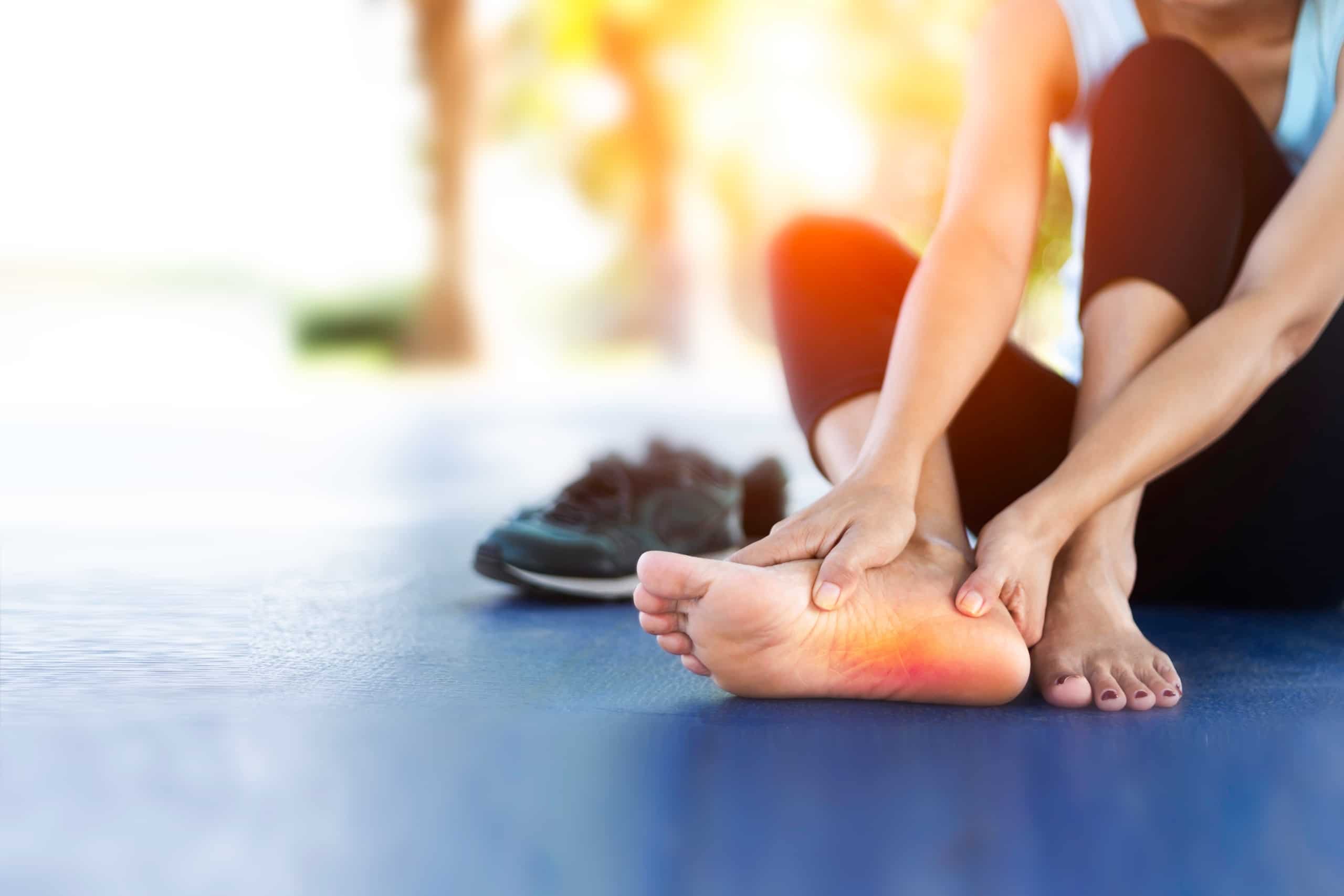 Close up of a woman gripping her foot in pain