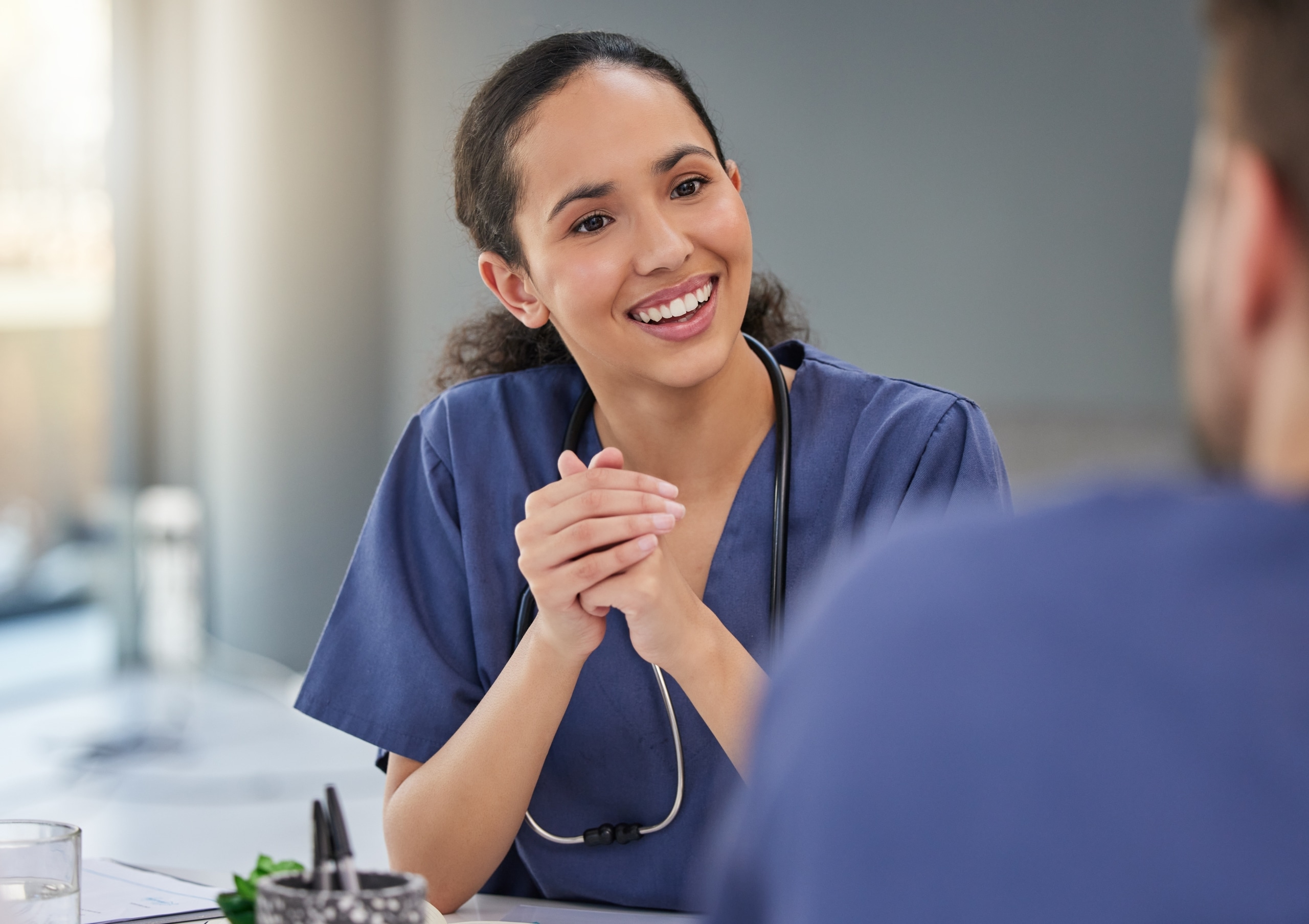 Beautiful nurse smiling as she meets with the healthcare team