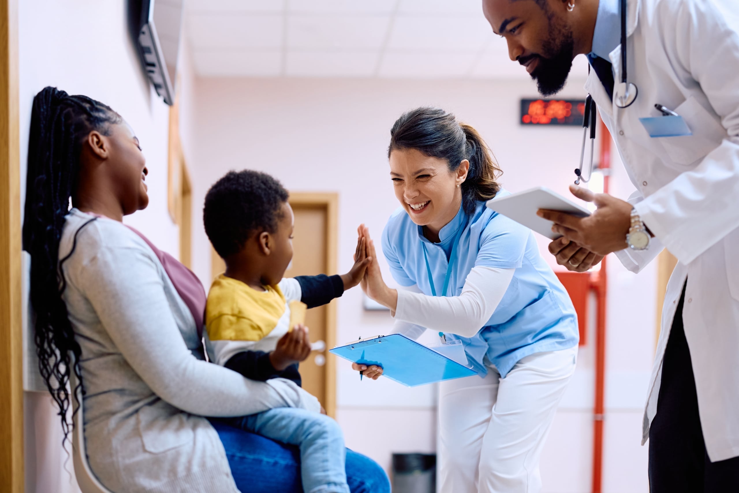Happy medical professional giving a high five to a pediatric patient
