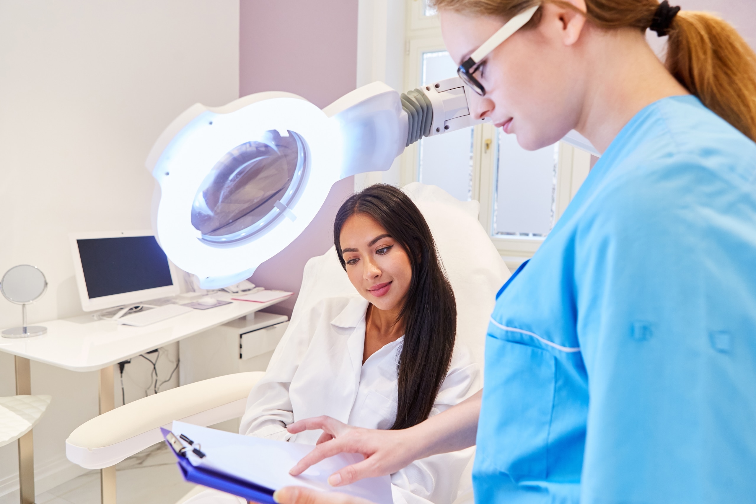 Dermatology professional speaking with a patient at an office