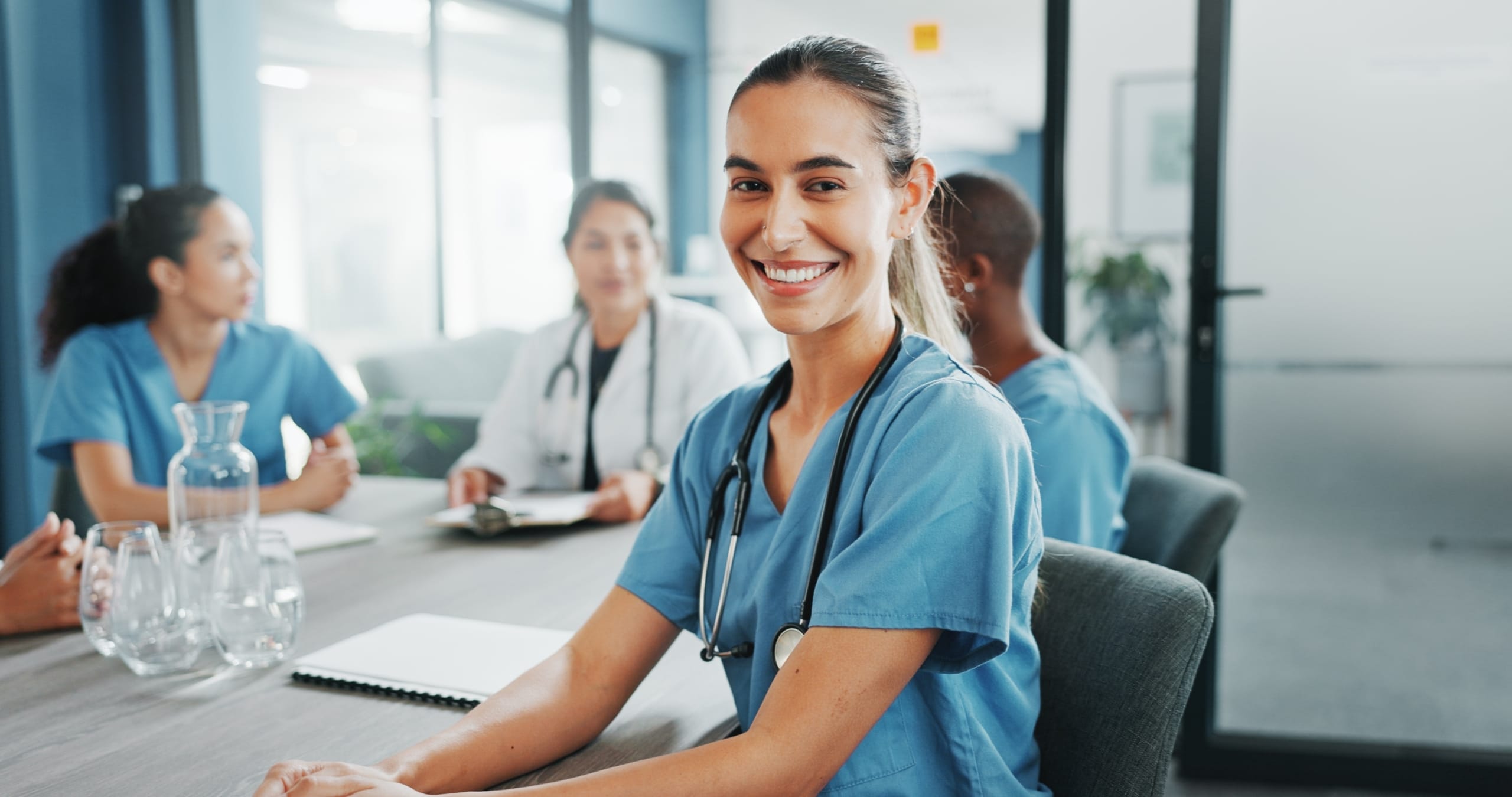 Smiling medical professionals sitting at a conference table