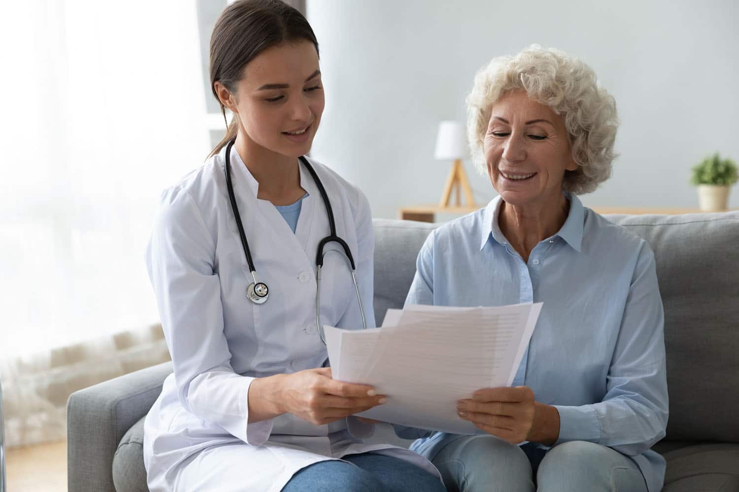 Medical professional helping a senior patient complete paperwork
